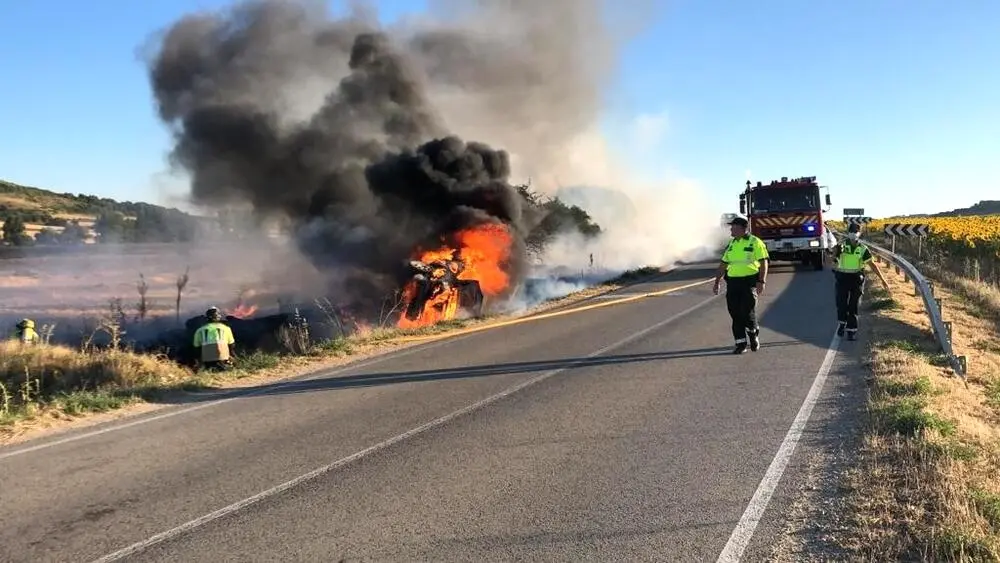 Imagen de archivo de un accidente de tráfico con un vehículo ardiendo tras haberse salido de la vía y volcar