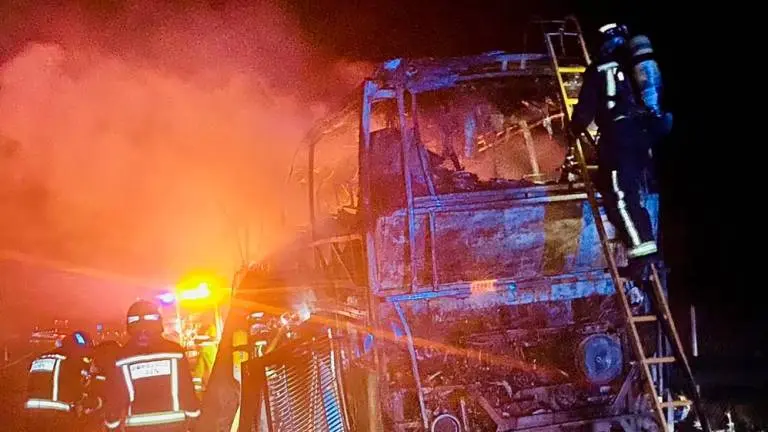 En la imagen de archivo bomberos extinguen un autobús incendiado tras un accidente de tráfico