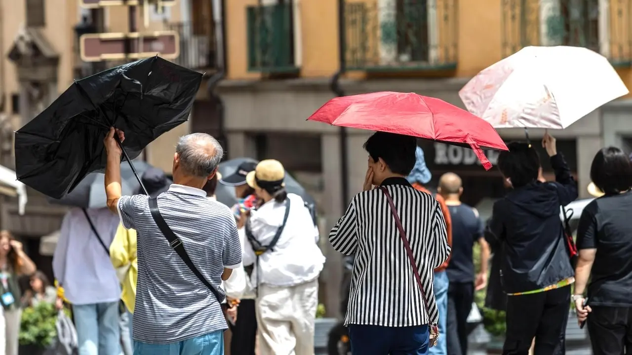 Varios turistas se protegen del sol y el sofocante calor en la ciudad de Toledo ante las altas temperaturas - EFE/Ángeles Visdómine