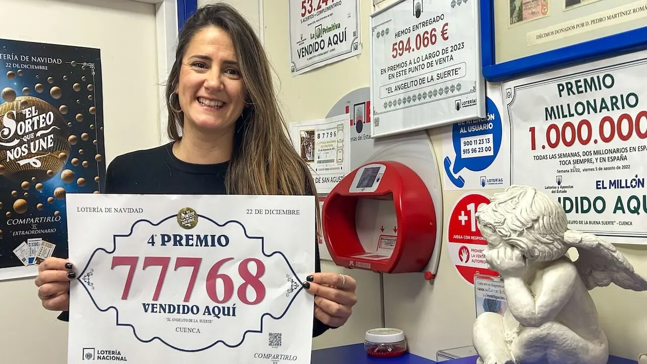 Clara Cañizares, lotera de la administración 10 'El Angelito de la Suerte' de Cuenca, muestra el número 77768, premiado con un cuarto premio del Sorteo Extraordinario de la Lotería de Navidad - EFE/Lorena Mayordomo