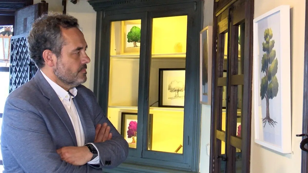 El periodista Jesús Espada, observa una de las obras que expone - EP