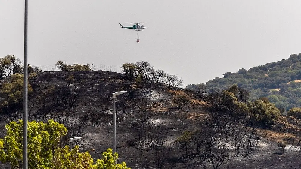 Un helicóptero refresca la zona afectada por el incendio forestal originado el pasado lunes en Navalmoralejo (Toledo) - EFE/Ismael Herrero