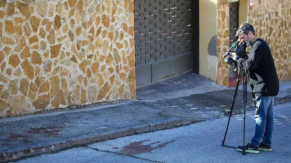 Un reportero toma imágenes de una mancha de sangre este lunes en El Casar de Escalona (Toledo) tras la operación de la Policía Nacional en la que ha fallecido uno de los presuntos narcotraficantes y otros tres han resultado heridos -dos de ellos por arma de fuego - EFE/Manu Reino