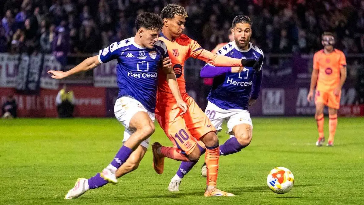 El delantero del FC Barcelona, Lamine Yamal (c), intenta llevarse el bal&oacute;n ante los defensores del CD Guadalajara durante el encuentro correspondiente a los dieciseisavos de final de la Copa del Rey en el estadio Pedro Escart&iacute;n, en Guadalajara - EFE/Nacho Izquierdo