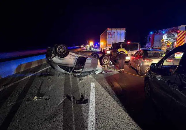 Imagen de archivo de un accidente de tr&aacute;fico m&uacute;ltiple con un turismo volcado