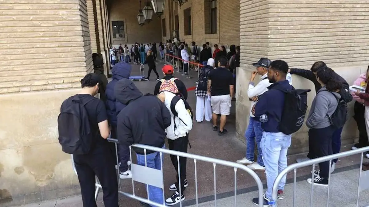 En la imagen personas inmigrantes hacen cola en una oficina de inmigraci&oacute;n para acogerse a la regularizaci&oacute;n de migrantes