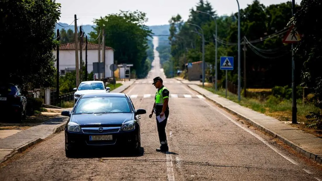 Un efectivo de la Guardia Civil informa de los cortes de carreteras de acceso a las diferentes localidades desalojadas en la comarca de Talavera de la Reina (Toledo) por los incendios forestales - EFE/Manu Reino