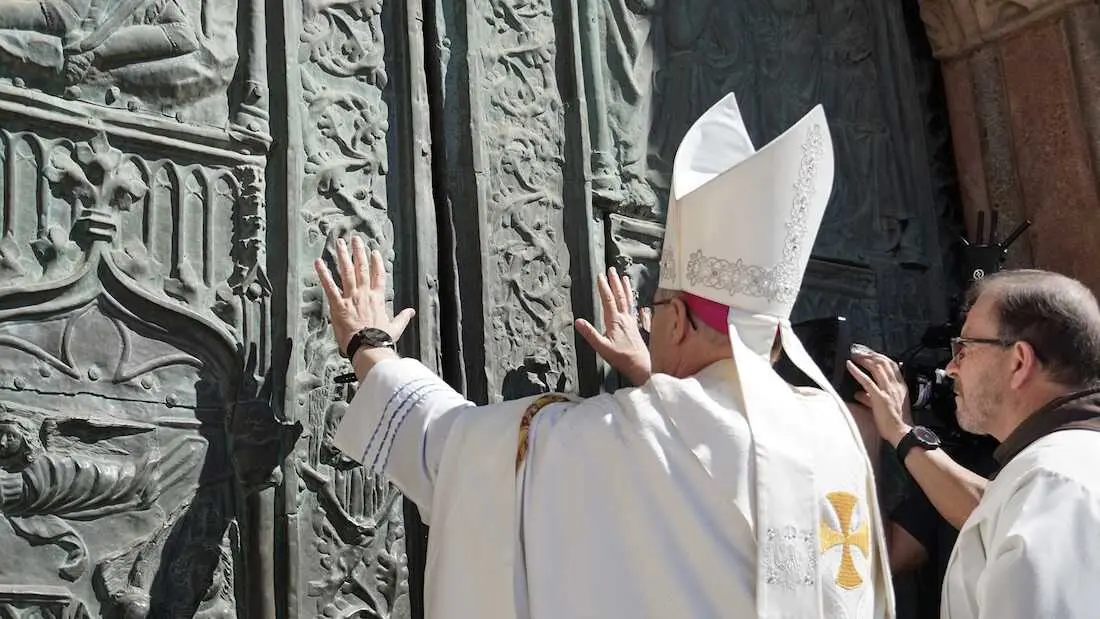 El arzobispo de Toledo y Primado de Espa&ntilde;a, Francisco Cerro Chaves, empuja con las manos la Puerta Jubilar del Monasterio de Santa Mar&iacute;a de Guadalupe durante la ceremonia de apertura del A&ntilde;o Santo Guadalupense 2026-2027, celebrada este domingo 30 de agosto.