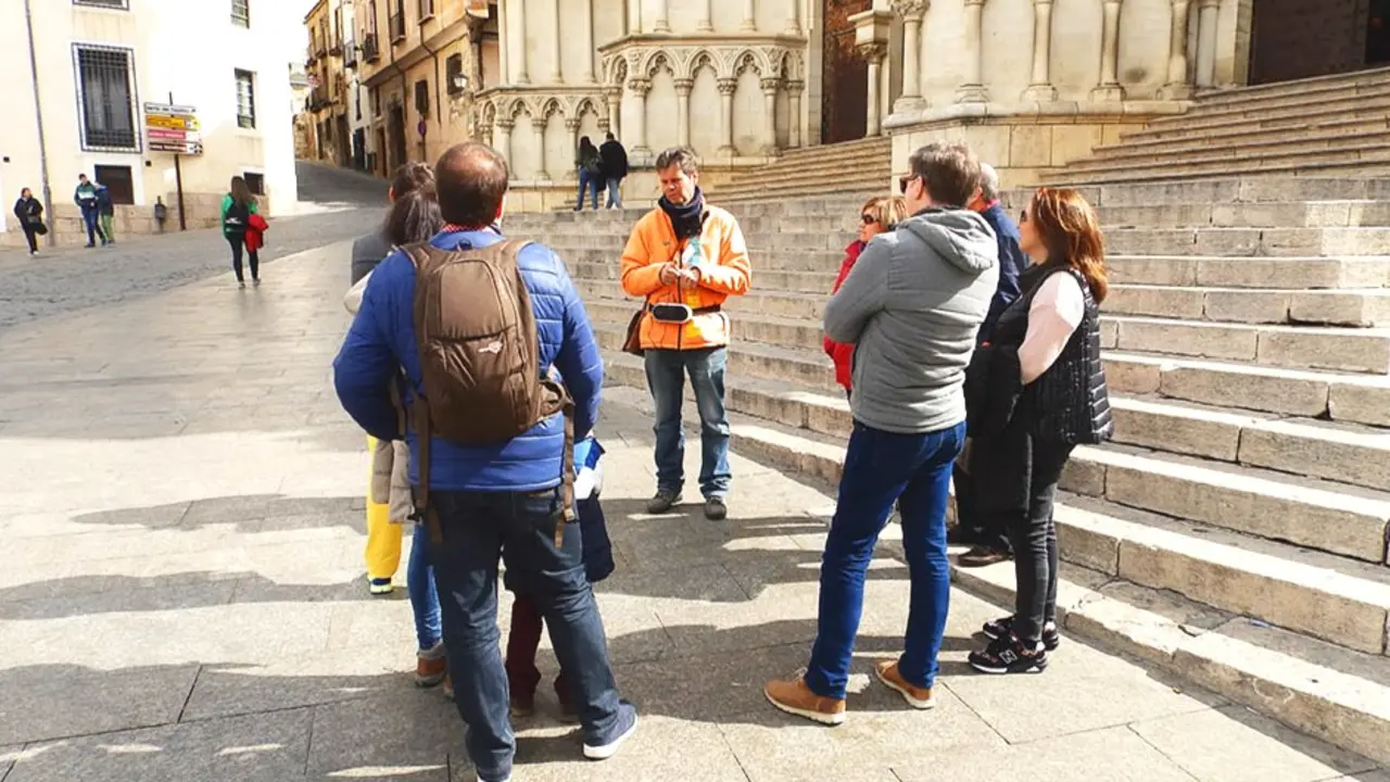 En la imagen un grupo de turistas atiende la explicación de un guía ante la Catedral de Cuenca, viajeros, guía turístico, turismo,&nbsp;