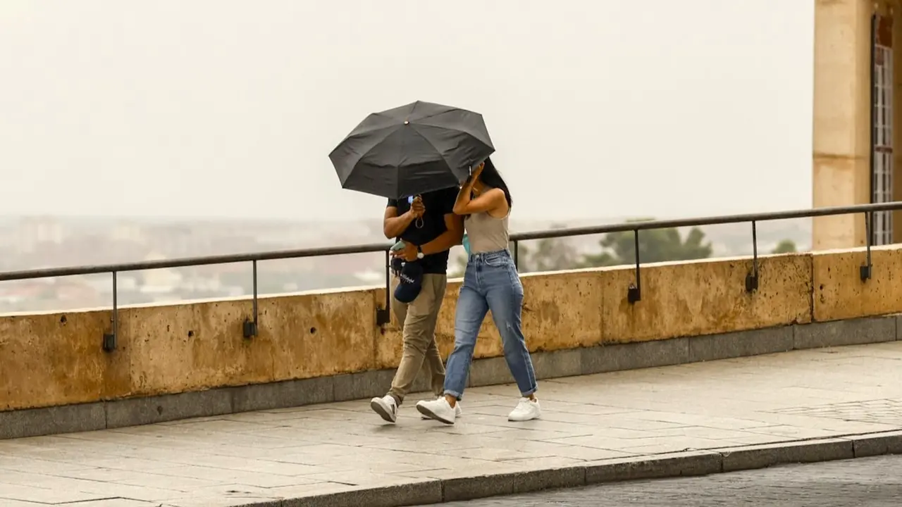 Una pareja se protege de la lluvia este jueves en Toledo. La Agencia Estatal de Meteorología (Aemet) prevé un otoño más cálido y más húmedo de lo habitual, sin descartar nuevos episodios de fuertes tormentas a causa de una nueva DANA - EFE/Ismael Herrero