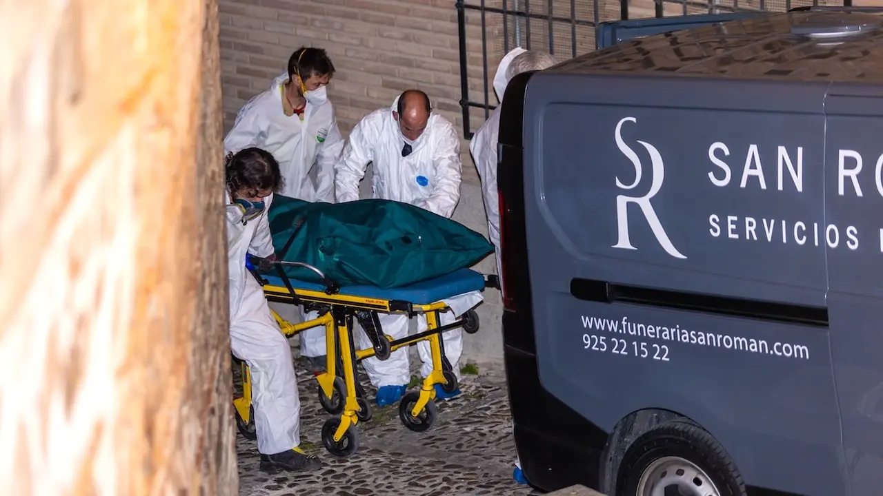 Miembros de los servicios funerarios transportan uno de los cuatro cadáveres encontrados en la vivienda de la calle Santa Leocadia, 12 del Casco Histórico de la ciudad de Toledo - EFE/Ángeles Visdómine