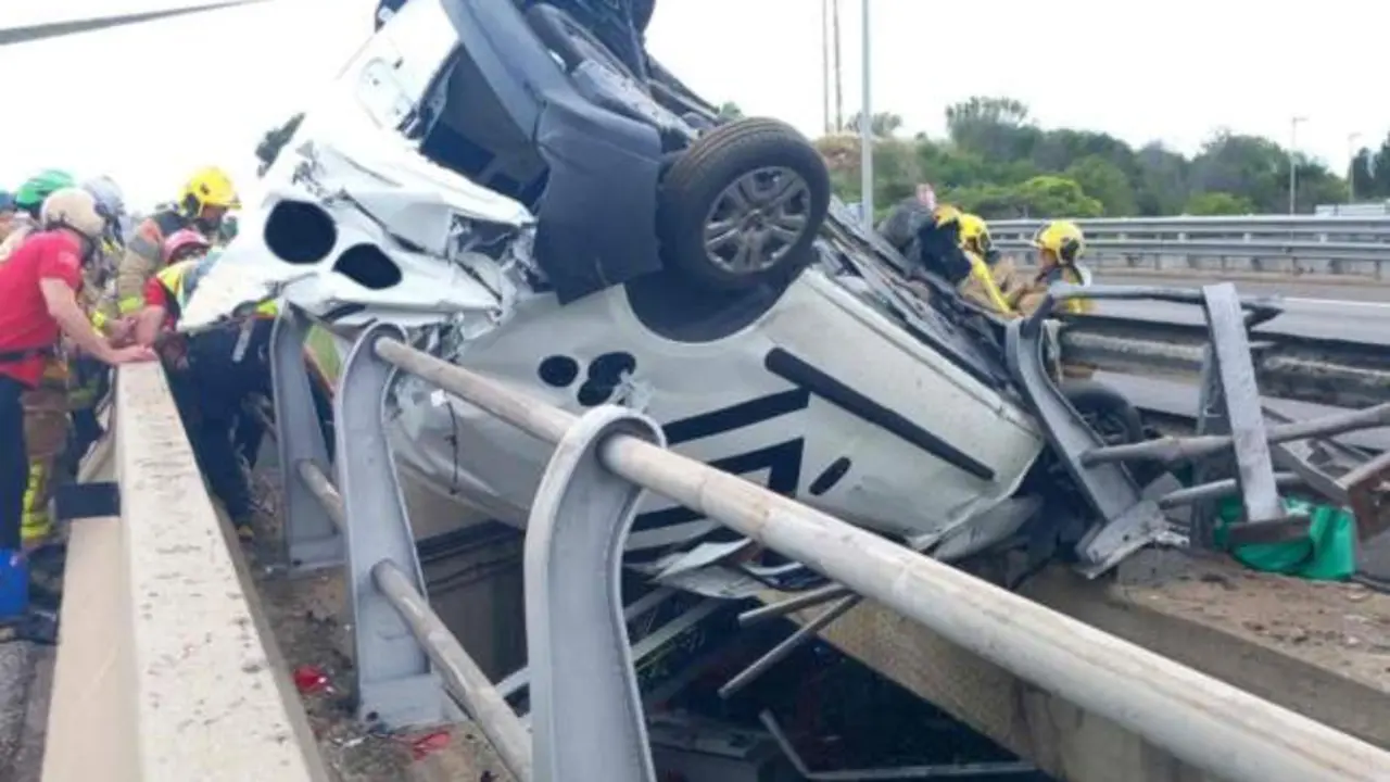 Aparatoso accidente de tráfico: un coche acaba volcado y colgando sobre un puente