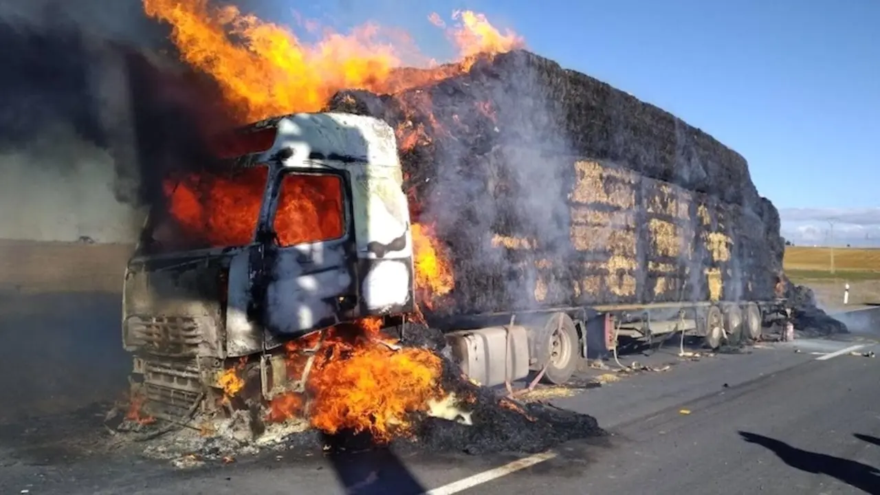 Imagen de archivo un camión cargado de pacas de paja incendiado en una carretera