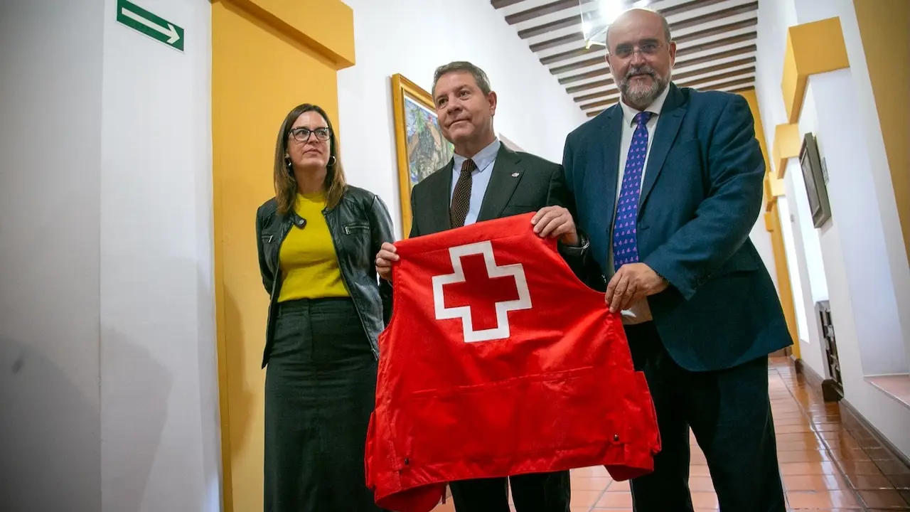 El presidente de Castilla-La Mancha, Emiliano García-Page, posa junto a un chaleco de Cruz Roja Española en el Parlamento regional y defiende la labor de la ONG frente a los "bulos" de Vox