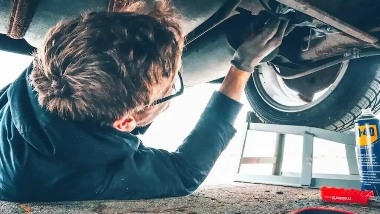 En la imagen de archivo un mecánico bajo un coche realizando una reparación