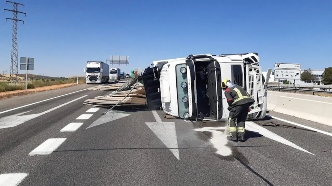 Imagen de archivo de un accidente de tráfico con un camión implicado tras volcar en la carretera