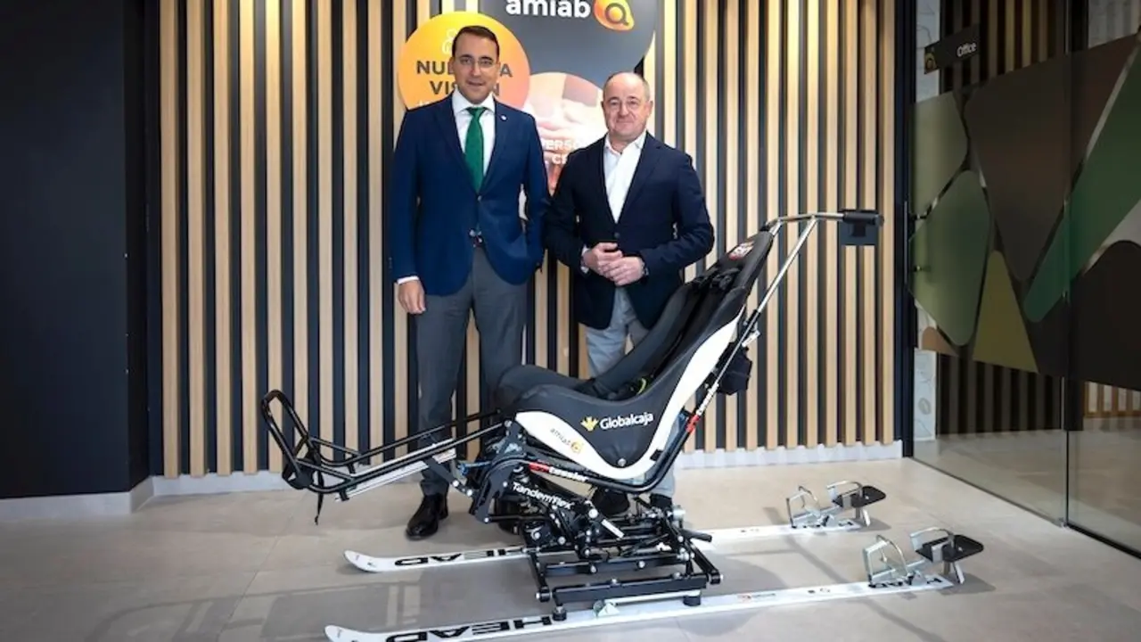 Pedro Palacios, director general de Globalcaja y Emilio Sáez, presidente de Amiab, presentan la silla de esquí adaptada que han adquirido gracias a una acuerdo entre las dos entidades