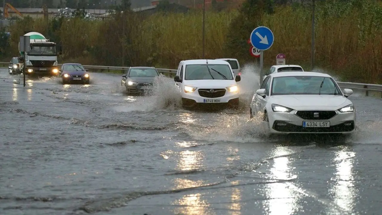 En la imagen de archivo vehículos transitan por una carretera llena de agua tras una fuerte tormenta con fuertes lluvias, temporal, DANA, corte de carretera, carretera cortada, circulación, tráfico, tormenta,