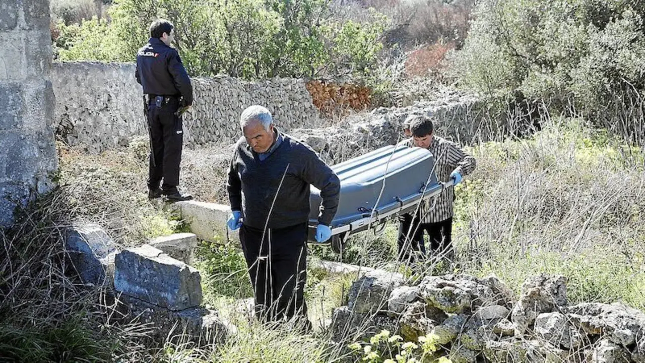 En la imagen de archivo de Menorca.info operarios trasladas un cadáver hallado en un paraje custodiados por Policía Nacional