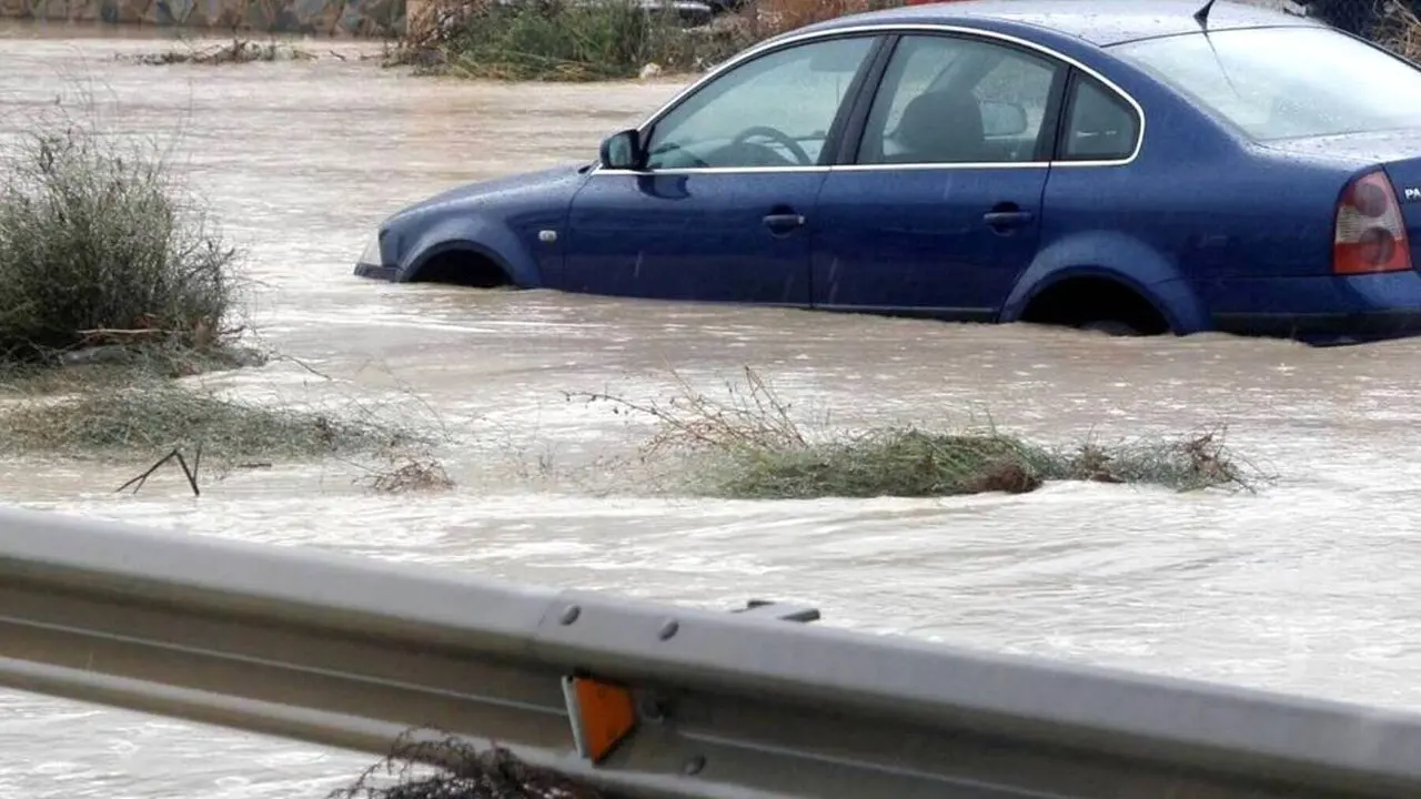 Imagen de archivo de un coche atrapado en una riada en una carretera tras desbordarse un río por intentas precipitaciones, tormenta, temporal, borrasca, lluvias, inundaciones, desbordamiento, arroyo,