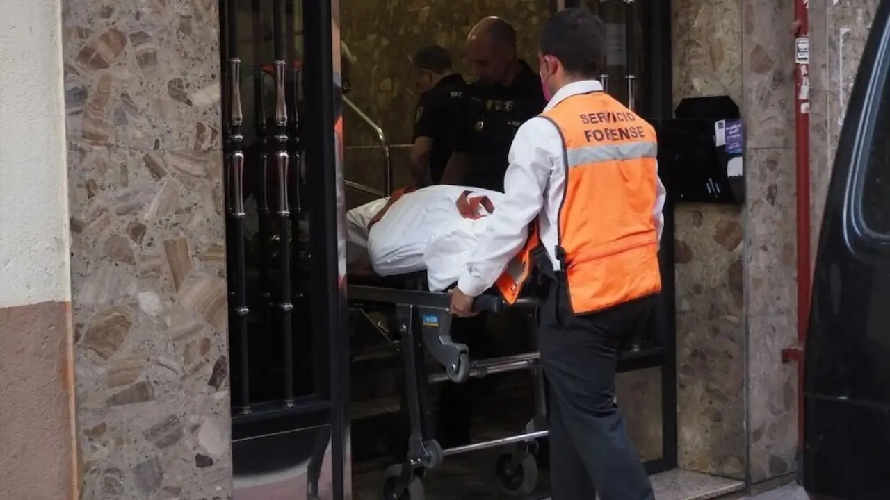 En la imagen de archivo servicios forenses sacan el cadáver de una víctima de un portal