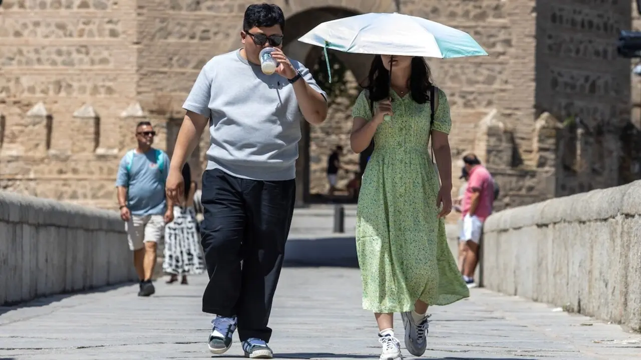 Los turistas se protegen del sol durante la ola de calor en Toledo este domingo - EFE/Ángeles Visdómine