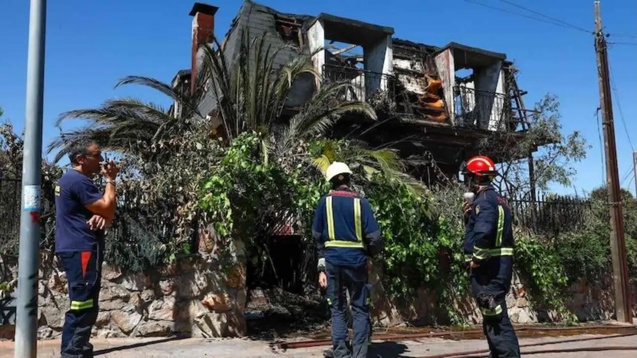 En la imagen bomberos ante una de las viviendas de la urbanización Calypo Fado afectadas por el incendio forestal de Méntrida (Toledo) - EFE/Ángeles Visdómine