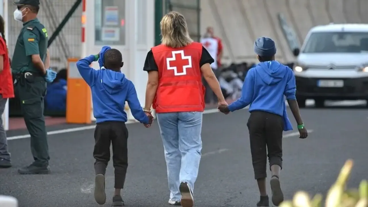 Un efectivo de la Cruz Roja escolta a dos de los menores migrantes, en una imagen de archivo - EFE/Gelmert Finol, inmigración, menas, inmigrantes,&nbsp;