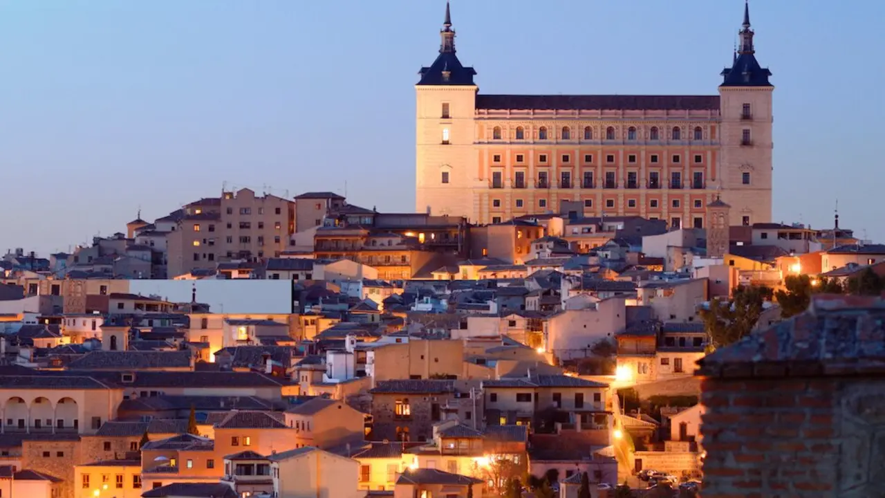 En la imagen una de las vistas de la ciudad de Toledo anocheciendo con el Alcázar de fondo