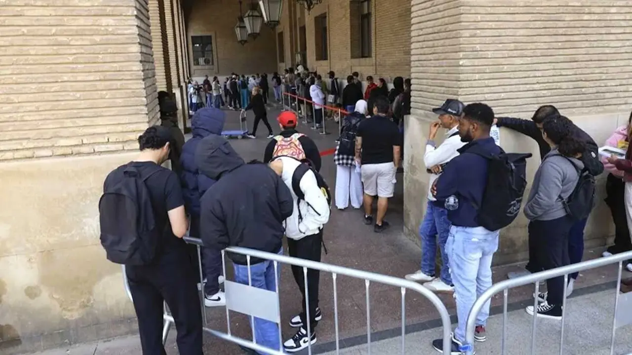 En la imagen personas inmigrantes hacen cola en una oficina de inmigraci&oacute;n para acogerse a la regularizaci&oacute;n de migrantes