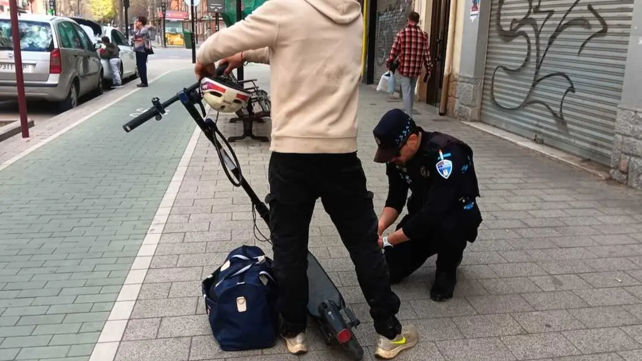En la imagen de archivo un polic&iacute;a local de Albacete inspecciona en una calle un patinete el&eacute;ctrico