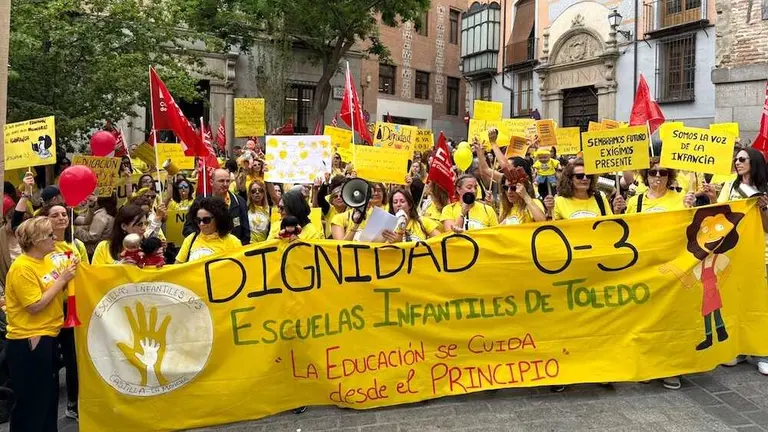 Educadoras de las escuelas infantiles de Toledo, camiseta amarilla y pancarta en mano, durante la concentraci&oacute;n ante la Delegaci&oacute;n del Gobierno en la capital regional, este jueves, en el marco de la primera huelga estatal del sector.